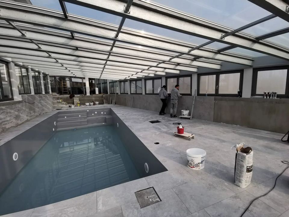 Poolterrasse aus grauem Feinsteinzeug mit Blick auf den Pool