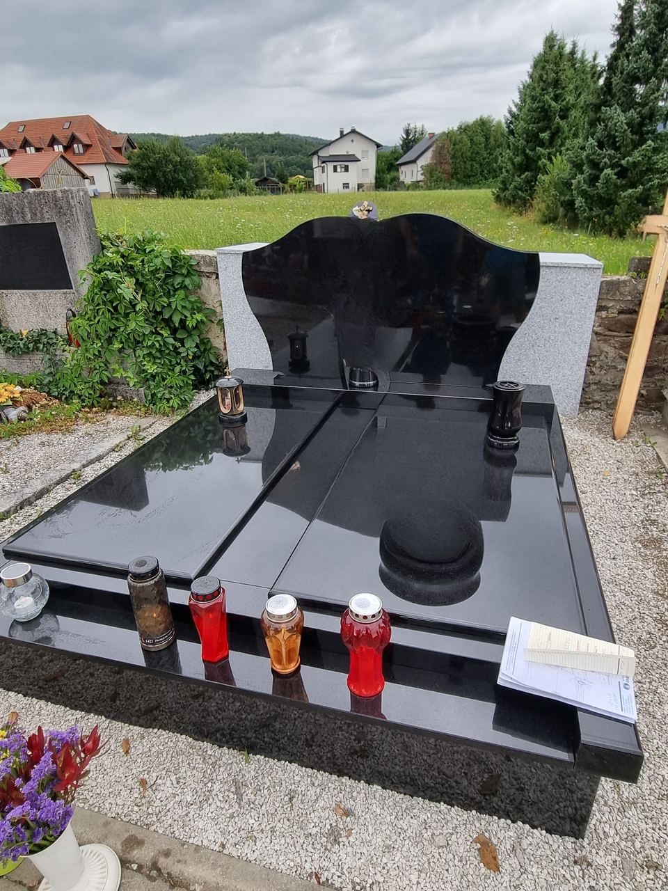Doppelgrabstein aus schwarzem Granit mit zwei flügelförmigen Stelen