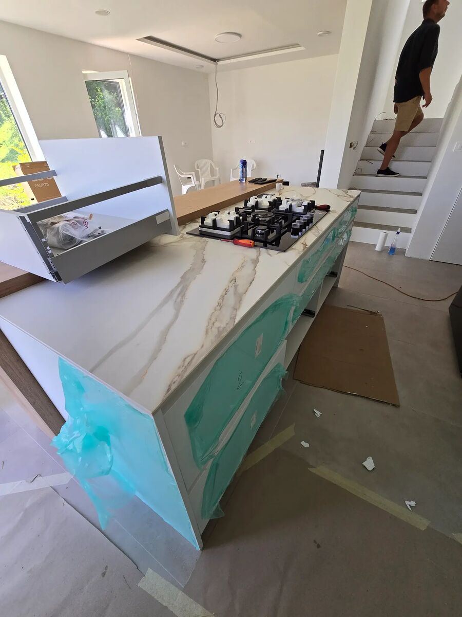 Kochinsel aus weißem Feinsteinzeug Calacatta während der Montage