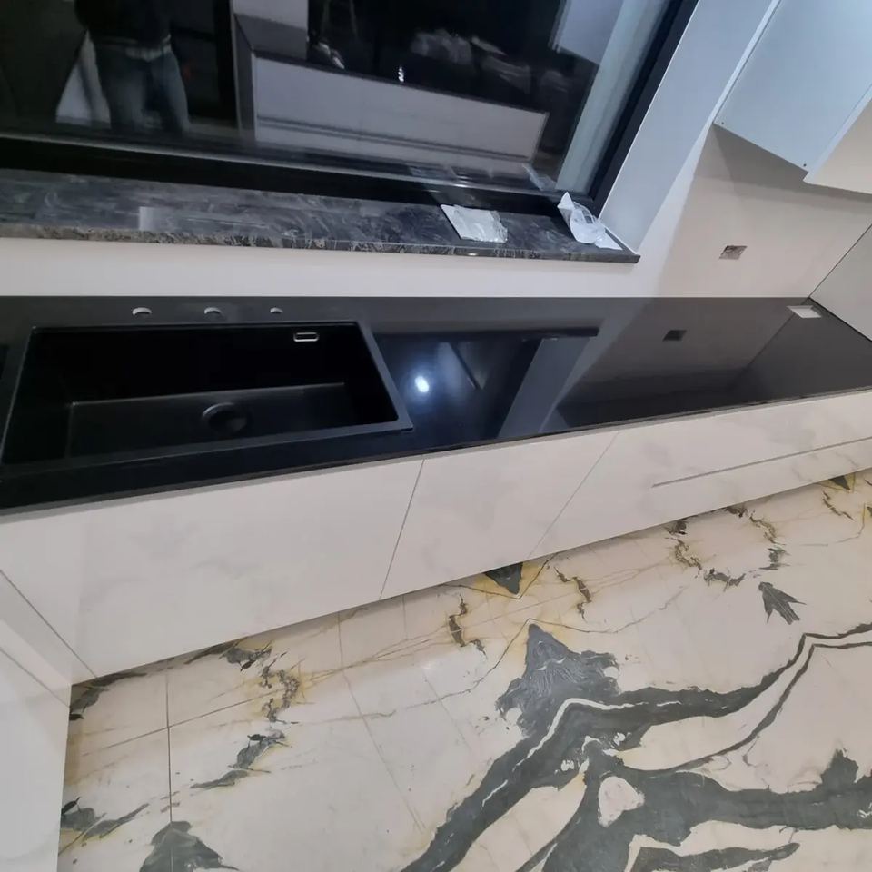 Arbeitsplatte und Kochinsel aus schwarzem Granit mit Marmorböden