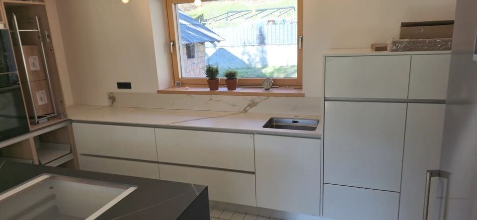 Arbeitsplatte aus weißem Feinsteinzeug Calacatta mit Kochinsel aus Granit