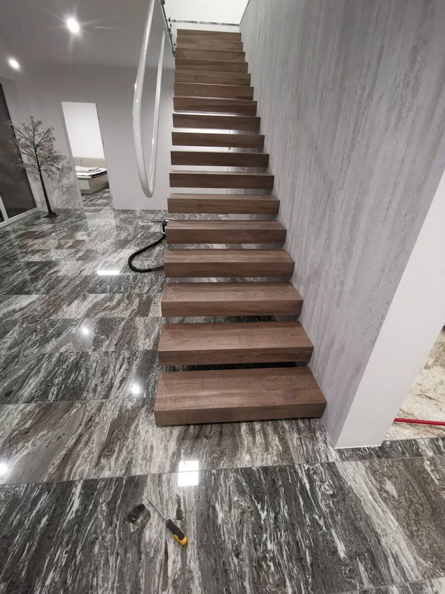 Luxuriöse Innentreppe mit Holzstufen und Granitböden