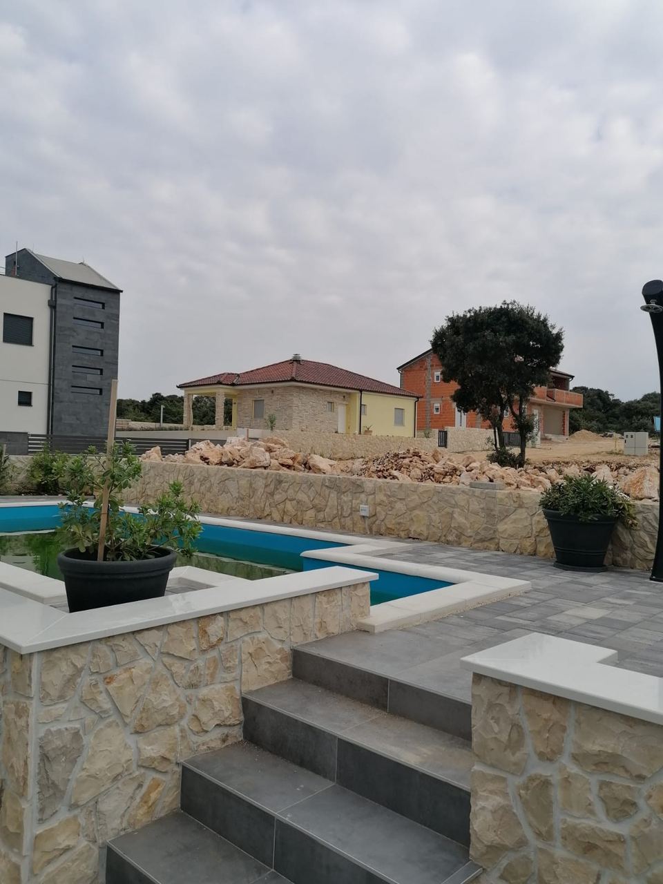 Stufen und Steinverkleidung der Mauer am Pool