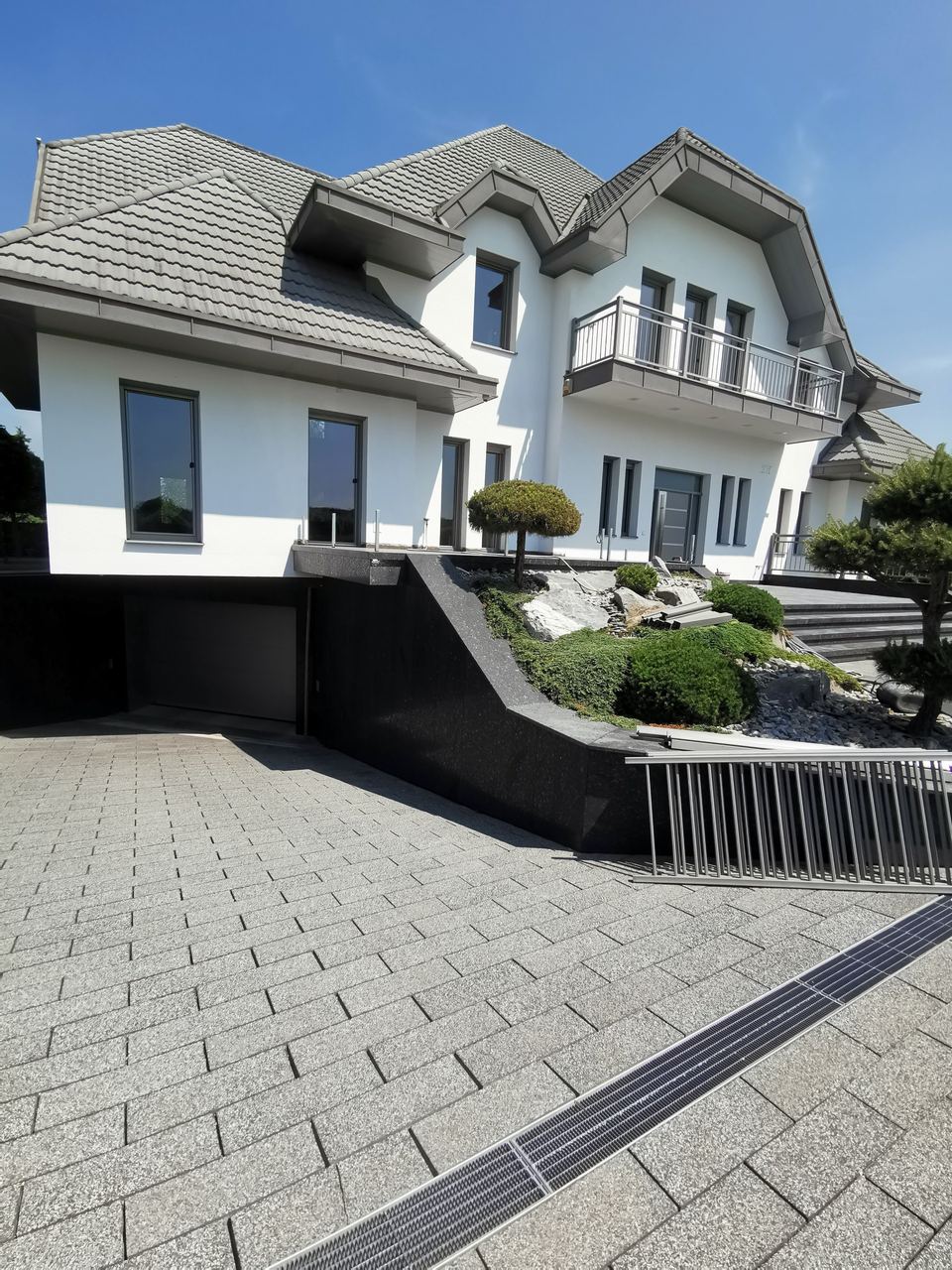 Terrasse mit Steinbelag und Einfassung aus schwarzem Granit