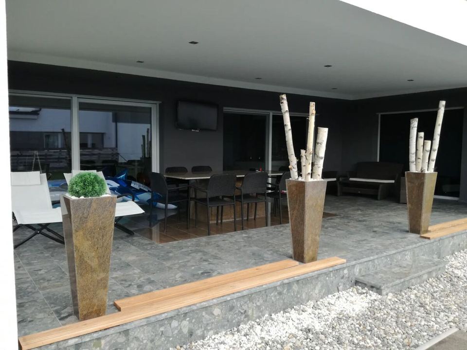 Terrasse mit Granitbelag und dekorativen Pflanzgefäßen