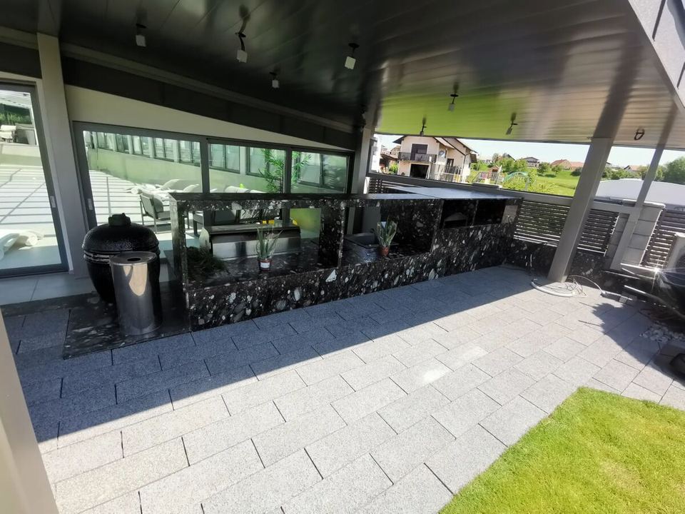 Große Außenküche aus schwarzem Granit mit eingebautem Grill