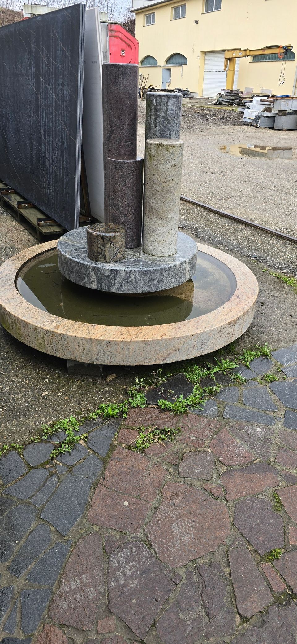 Gartenbrunnen aus Stein mit Säulen und rundem Becken